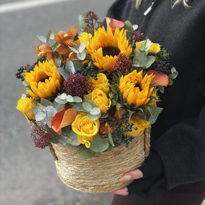 Композиция в сумке "Тональность" из подсолнухов, калл, ягод вибирнума, лимонных роз, скиммии и орхидеи в Черноголовке
